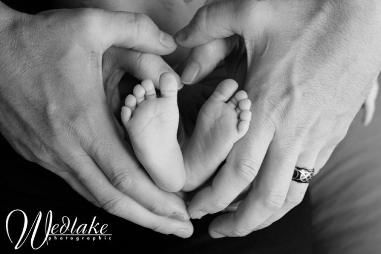 newborn baby feet with heart hands